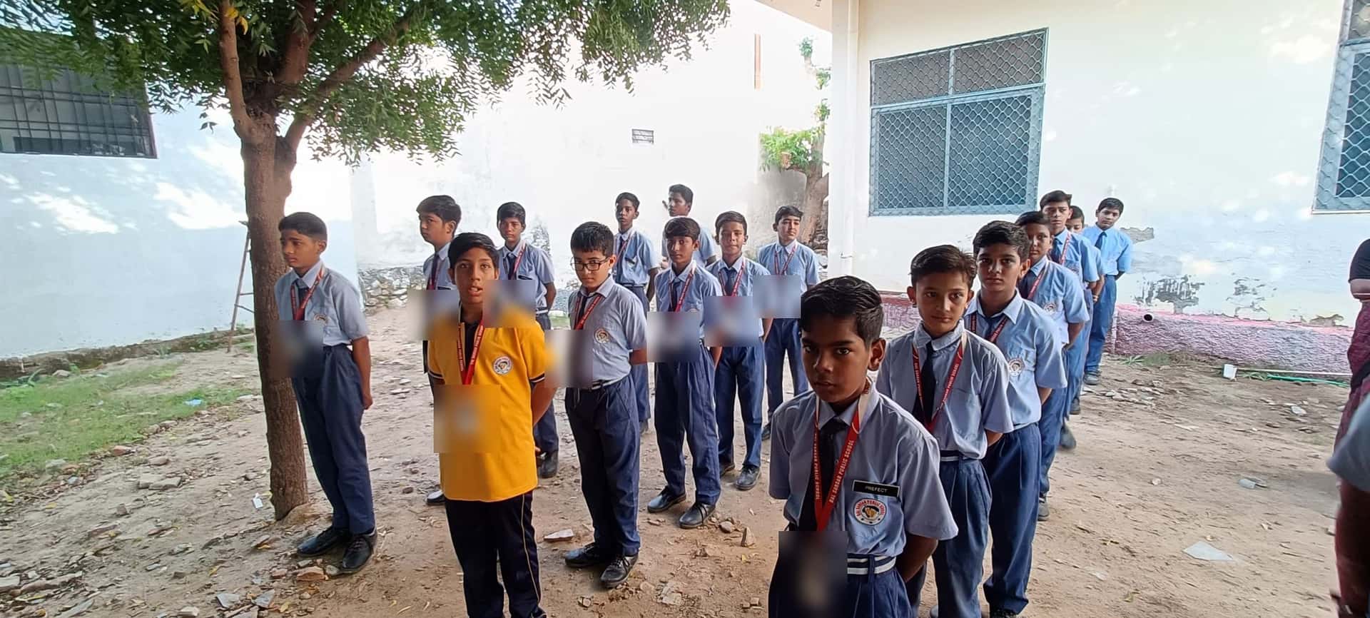 Boys in school uniform stand in their lines in the BSPS courtyard