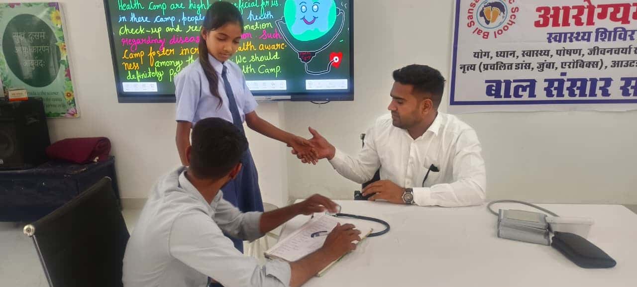 A student at the doctor's consultation table during the Aarogyam health camp