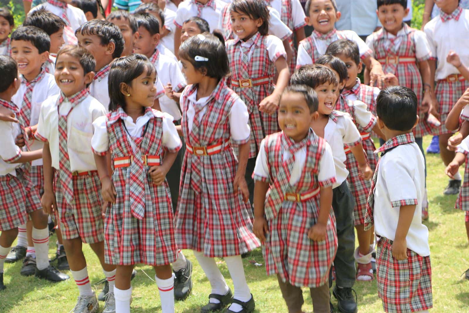 Joyful pre-primary students gathered on the school lawn