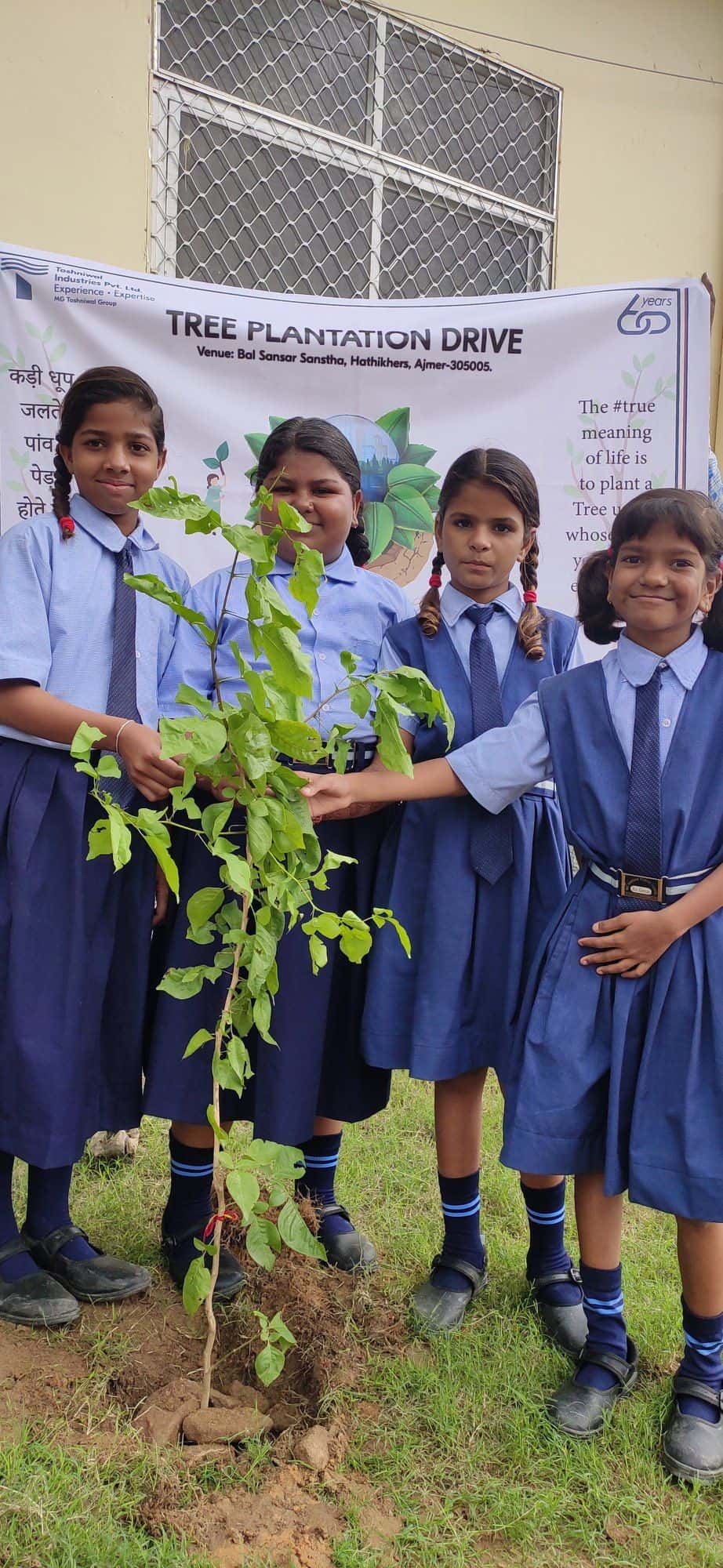 Students planting a sapling during a plantation drive