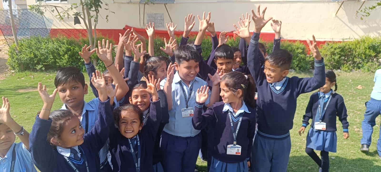 Students waving and smiling outdoors